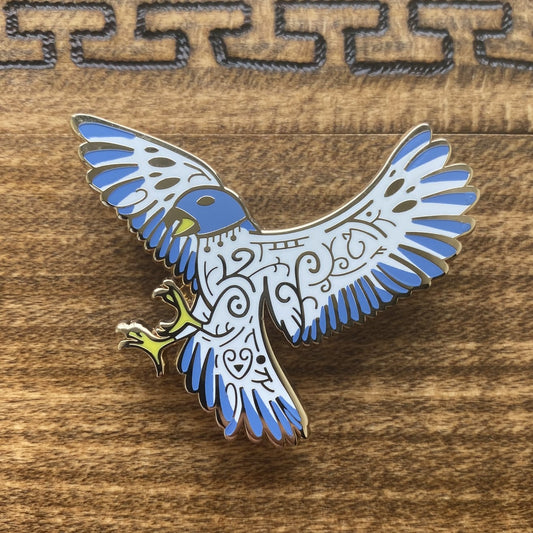 Gold-plated enamel pin of the Norse god Freyja. Pin contains knotwork and is depicted as a blue falcon.