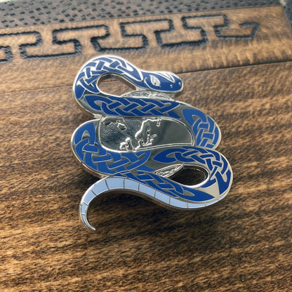 Silver-plated enamel pin of Jormungandr the Norse icon know as the Midgard serpent. The pin contains knotwork and depicts the snake circling the world. Angle shows off the silver-plating.