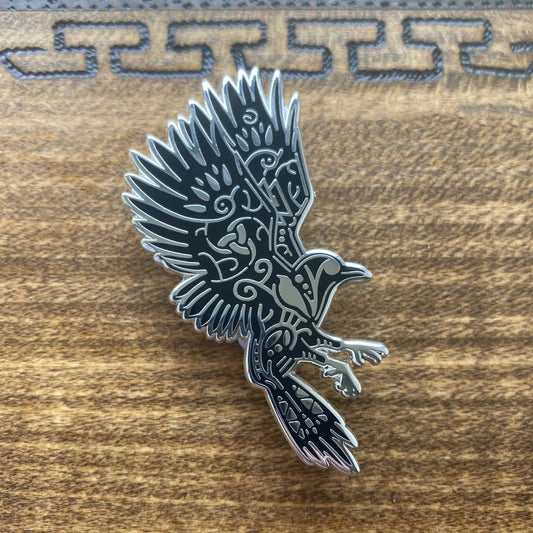 Norse god Odin, depicted as a raven enamel pin. The pin is silver plated and contains knotwork.